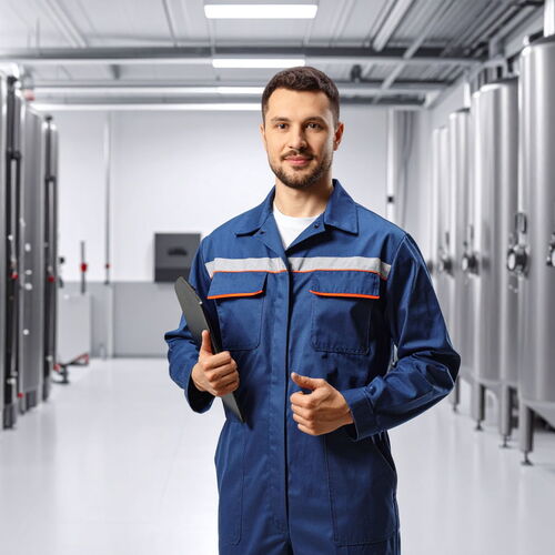 Anlagenmechatroniker vor großer Industrieheizungsanlage